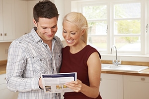 Young Couple Looking At Details For New Home